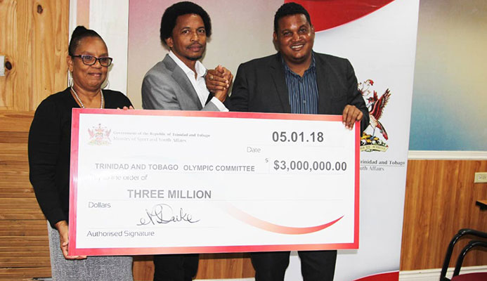 TEAM FUNDS: TTOC general secretary Annette Knott, left, and TTOC president Brian Lewis, centre, are presented with the ceremonial cheque by Minister of Sport and Youth Affairs Darryl Smith at Olympic House, Port of Spain recently.
