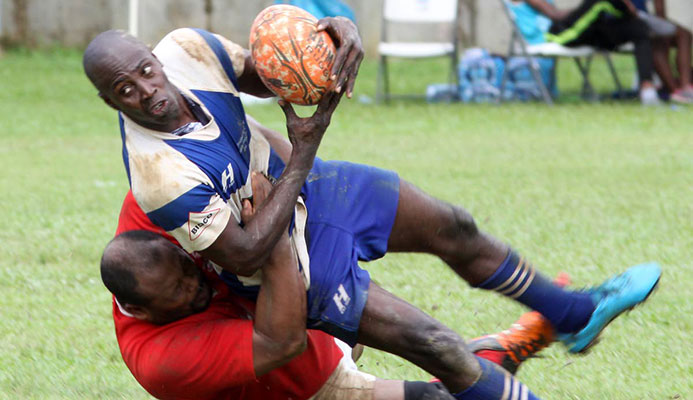 A UWI Tobago player (left) inflicts a crunching tackle on his Northern opponent at a match yesterday in the Police Sevens Rugby Tournament.