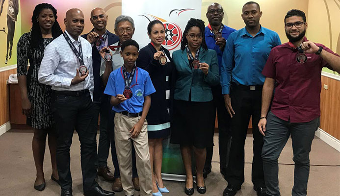Runners, who completed the BAFA Sports/TTOC Virtual 5K, pose with their medals during a distribution ceremony at TTOC Olympic House, Abercromby St, Port of Spain, yesterday.
