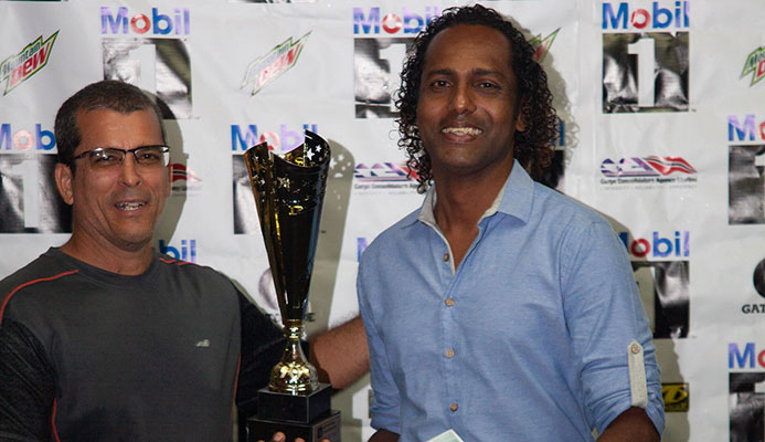 Chris Dennis, right, collects the “Surfer of the Year” award from Larry “Shrimpy” Coelho at the Surfing Association of T&T (SATT) prize giving ceremony on Saturday at Blue Range park, Diego Martin. @Brendan Delfil