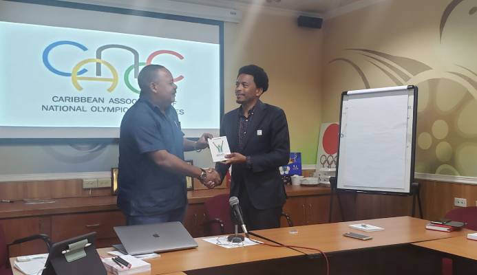 Guadeloupe’s Alain Soreze, left, makes a presentation to CANOC president Brian Lewis, TTOC during briefing of the CANOC executive committee to announced the inaugural Caribbean Games yesterday at Olympic House in Port-of-Spain.  Rachel Thompson-King