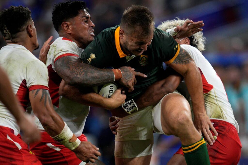 South Africa's Andre Esterhuizen, front, is tackled by Tonga's Malakai Fekitoa, left, and teammate Fine Inisi during the Rugby World Cup Pool B match at the Marseille's Stade Velodrome, in Marseille, France last Sunday. - AP (Image obtained at newsday.co.tt)
